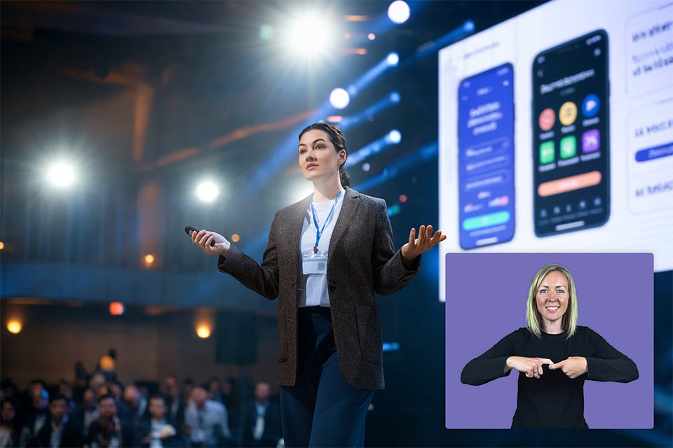 Image of a speaker on stage with an AI sign language avatar overlayed